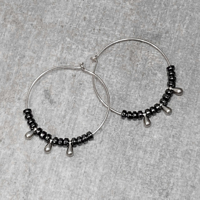 Dew Drops Earrings featuring elegant hematite beads on a silver hoop design for a stylish look.