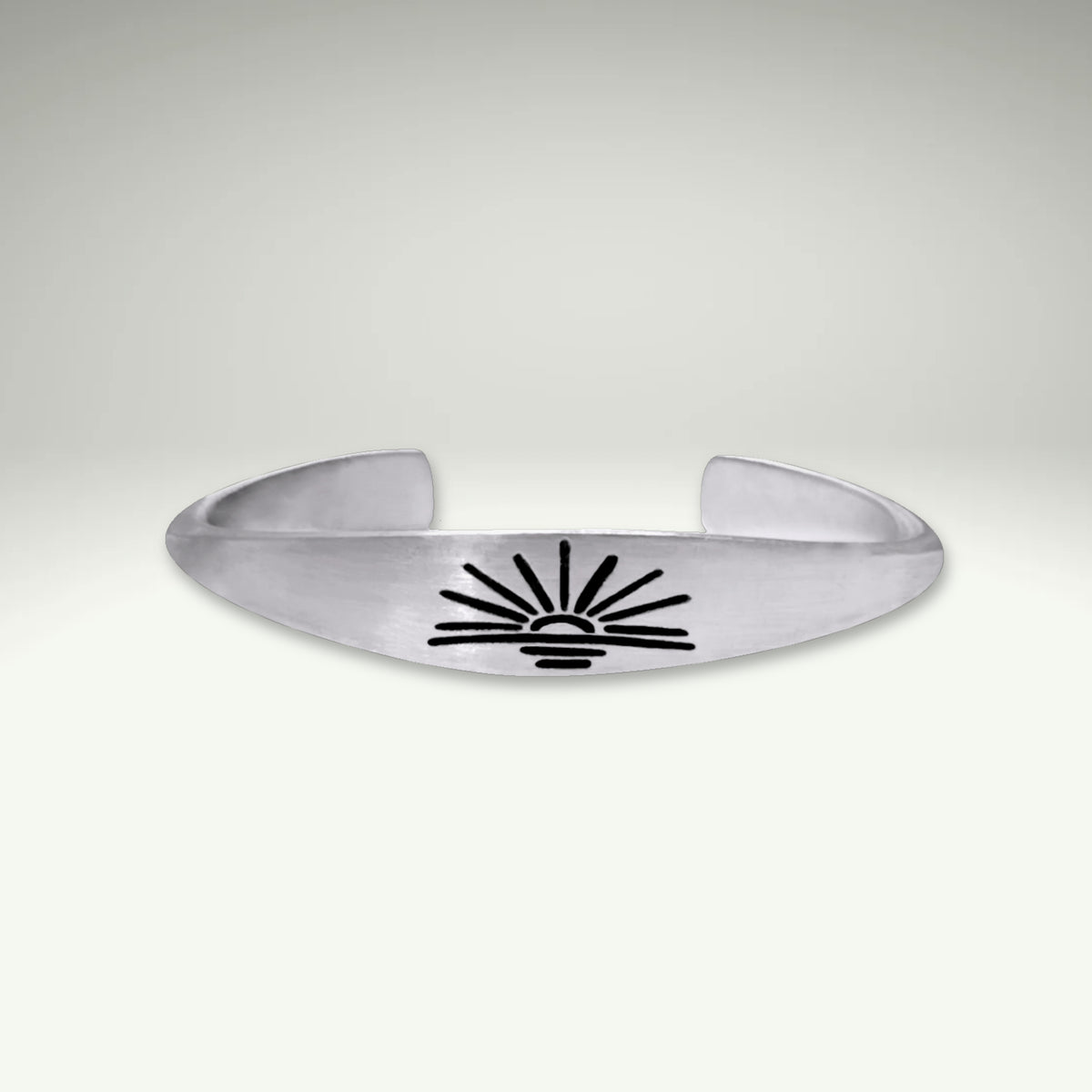 a silver bracelet with a sun design on it