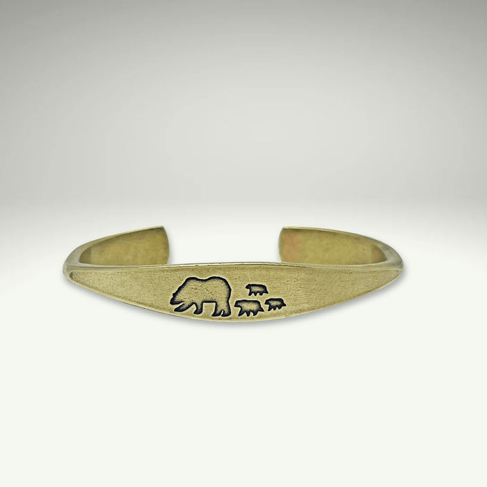 a gold bracelet with a bear and two sheep on it