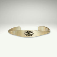 a gold bracelet with a lotus design on it