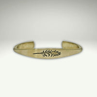 a gold bracelet with a design on it