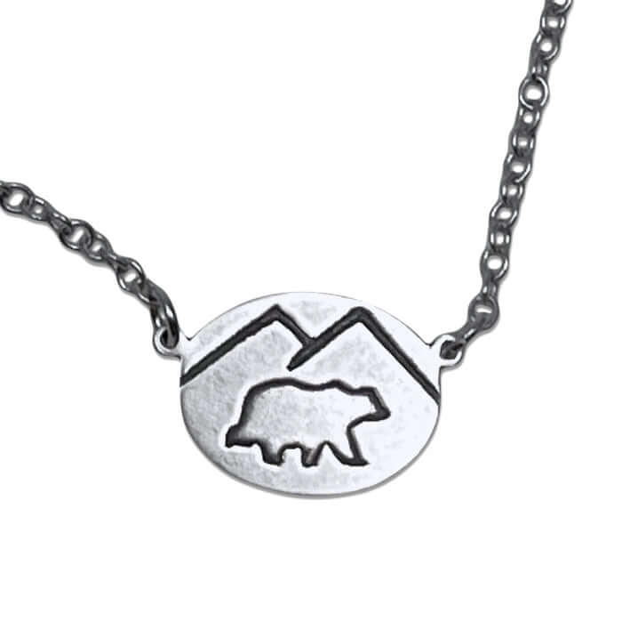 Mountain Bear Necklace in matte silver finish with mountain silhouette and bear pendant design, adjustable chain length.