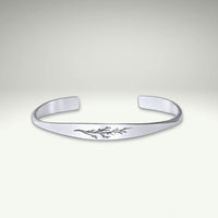 a silver bracelet with a floral design on it