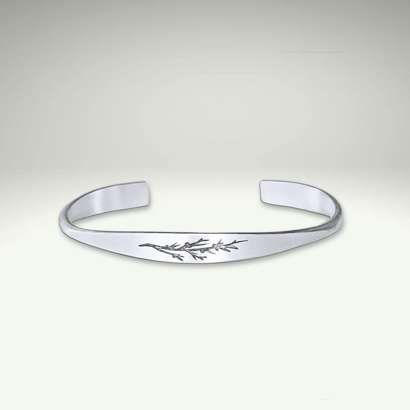 a silver bracelet with a floral design on it