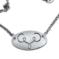 Ancient Buff Necklace with oval silver pendant and adjustable chain, inspired by the buffalo symbol.