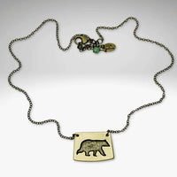 Bear Boy Necklace featuring a black bear charm on an asymmetrical rectangle pendant with a stylish chain.