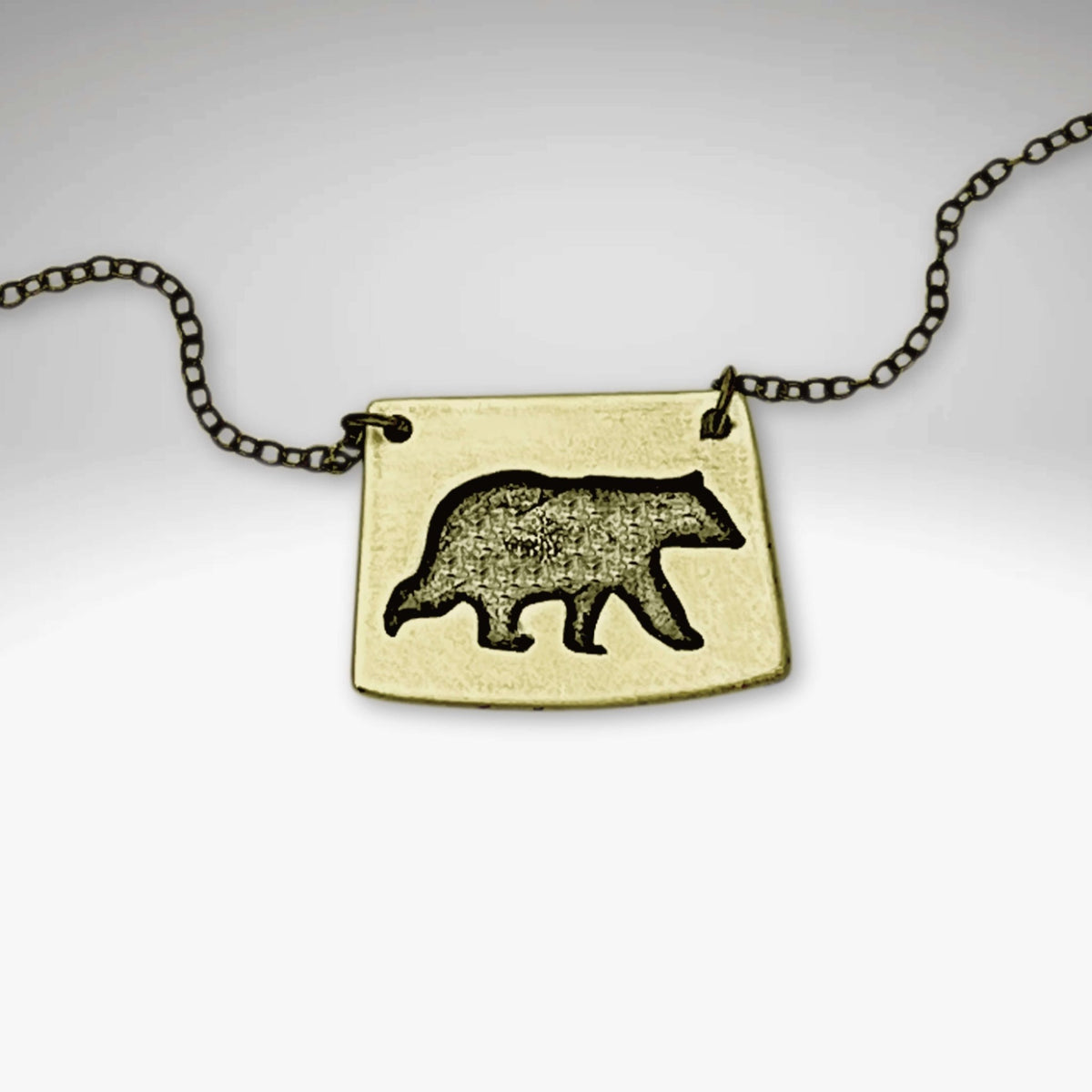 Bear Boy Necklace featuring a black bear design on a unique asymmetrical pendant.