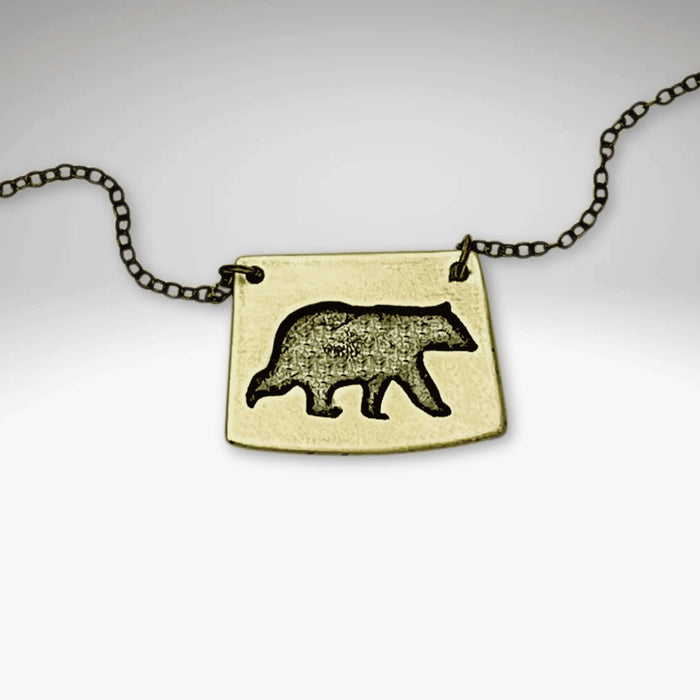 Bear Boy Necklace featuring a black bear design on a unique asymmetrical pendant.