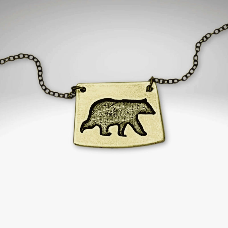 Bear Boy Necklace featuring a black bear design on a unique asymmetrical pendant.