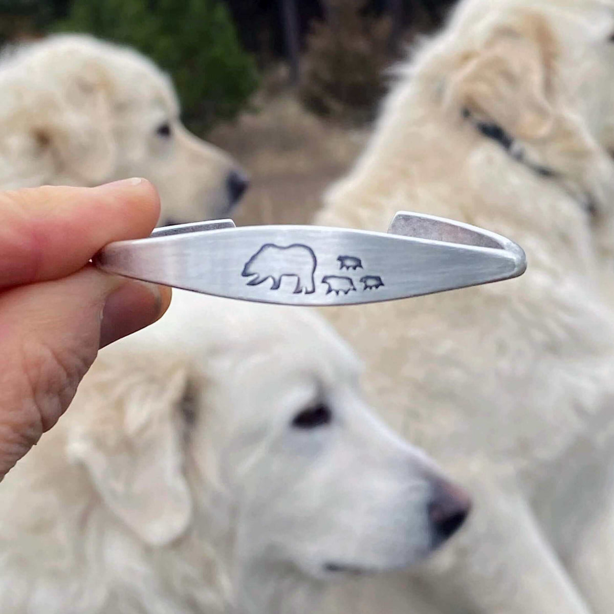 Bear Family Cuff Bracelet showcasing mama bear and cubs design against a backdrop of two white dogs.