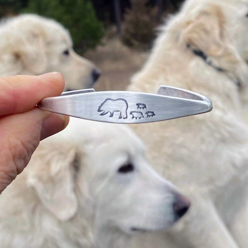 Bear Family Cuff Bracelet showcasing mama bear and cubs design against a backdrop of two white dogs.