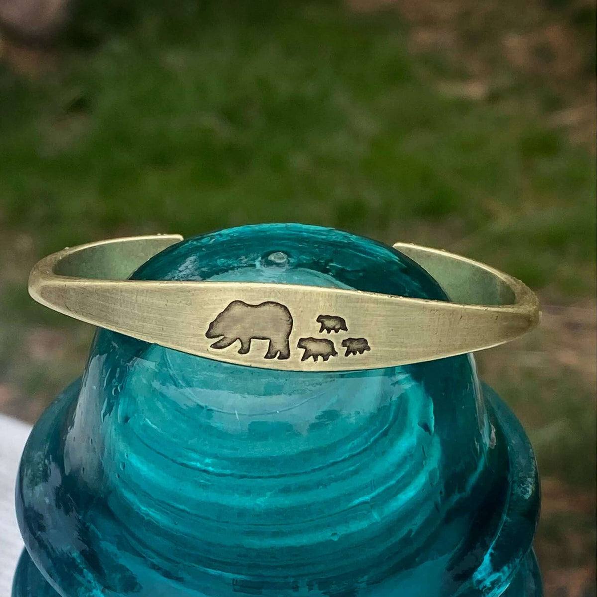 Bear Family Cuff Bracelet featuring mama bear and three cubs design on antique brass cuff against clear turquoise background