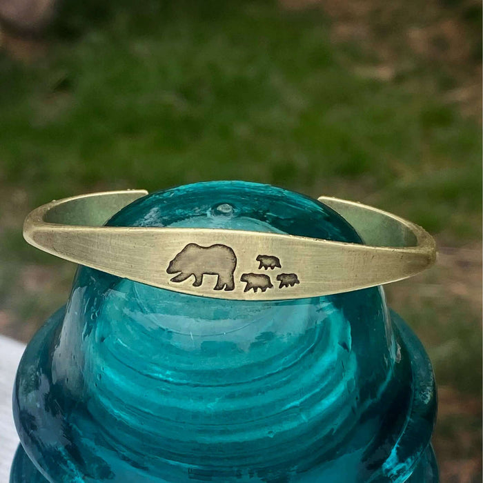 Bear Family Cuff Bracelet featuring mama bear and three cubs design on antique brass cuff against clear turquoise background
