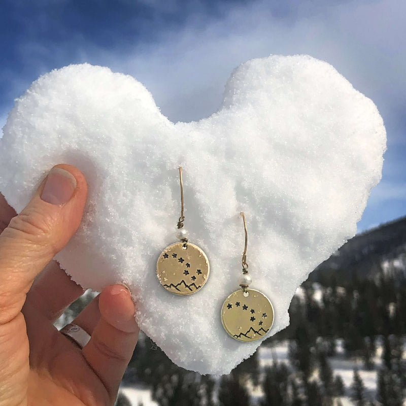 Big Dipper Earrings displayed against a heart-shaped snow background, showcasing their unique etched design and elegance.