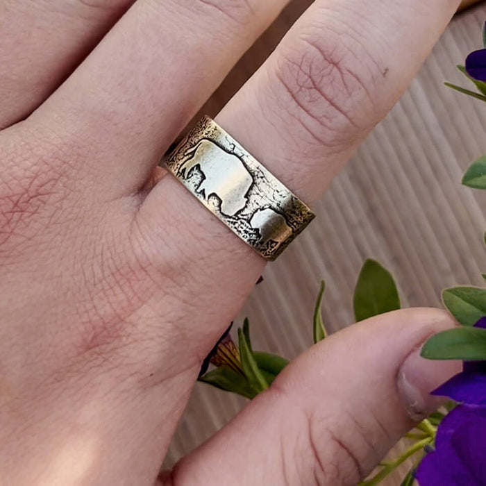 Bison Circles Adjustable Ring on a finger, showcasing the intricate bison motif design in Antique Brass.