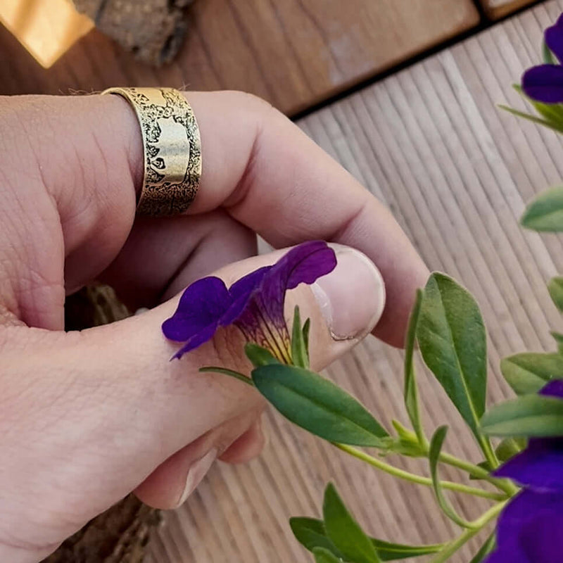 Bison Circles Adjustable Ring worn on hand holding a purple flower, showcasing the bison motif design.