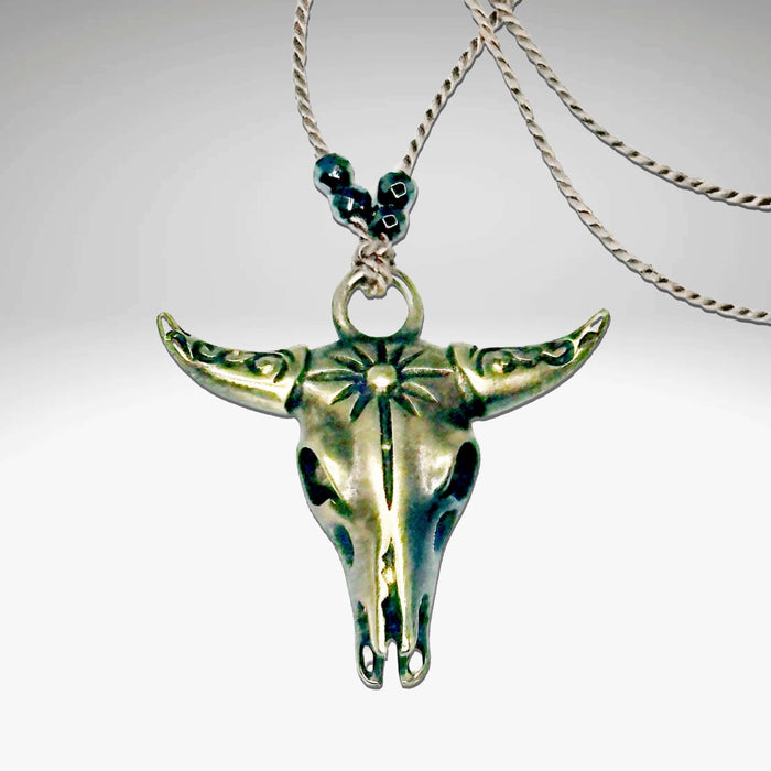 Bison Skull Necklace featuring a detailed pendant on a sleek silk cord with hematite beads, available in Matte Silver and Antique Brass.