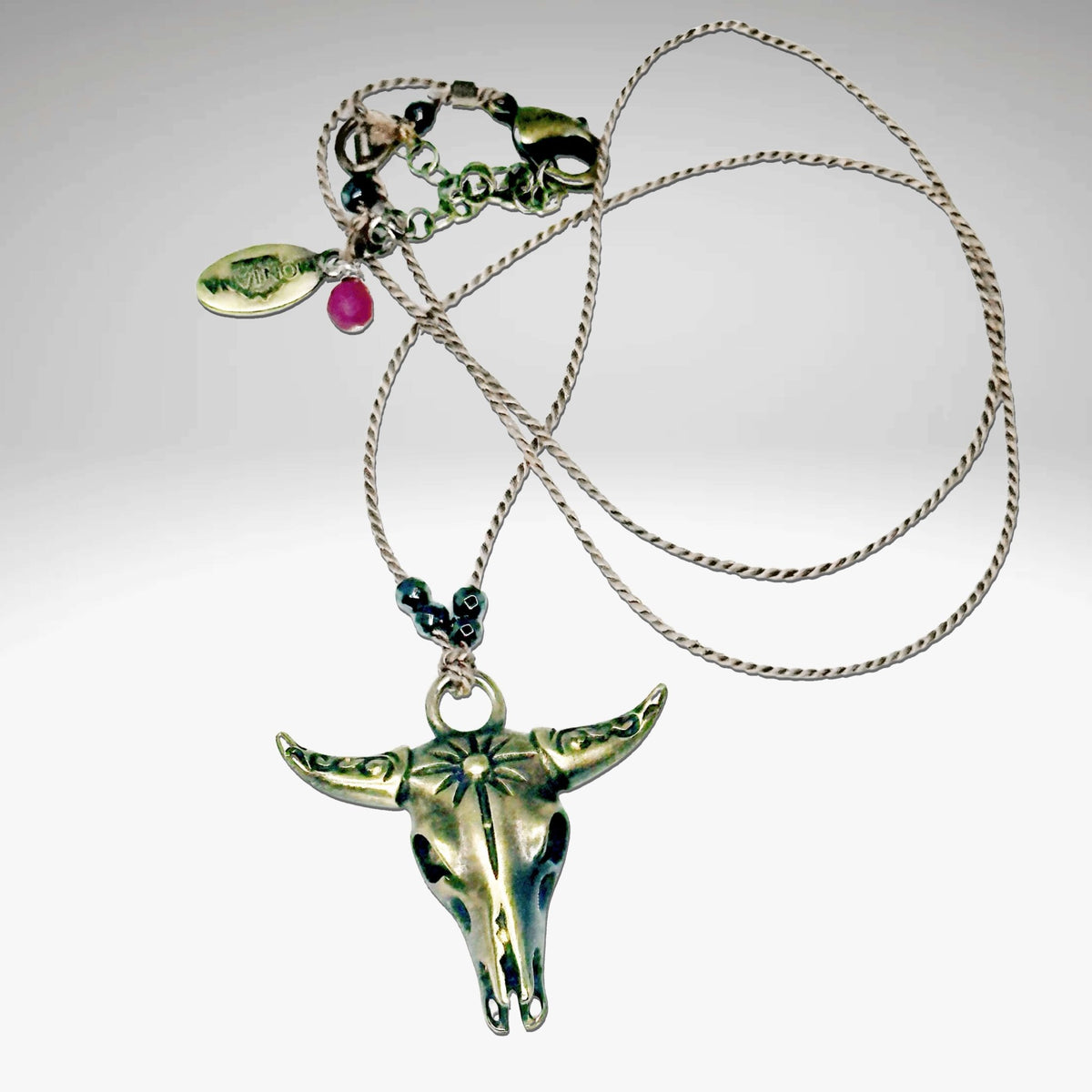 Bison Skull Necklace with intricate pendant on a silk cord, featuring hematite beads, adjustable from 16" to 18".