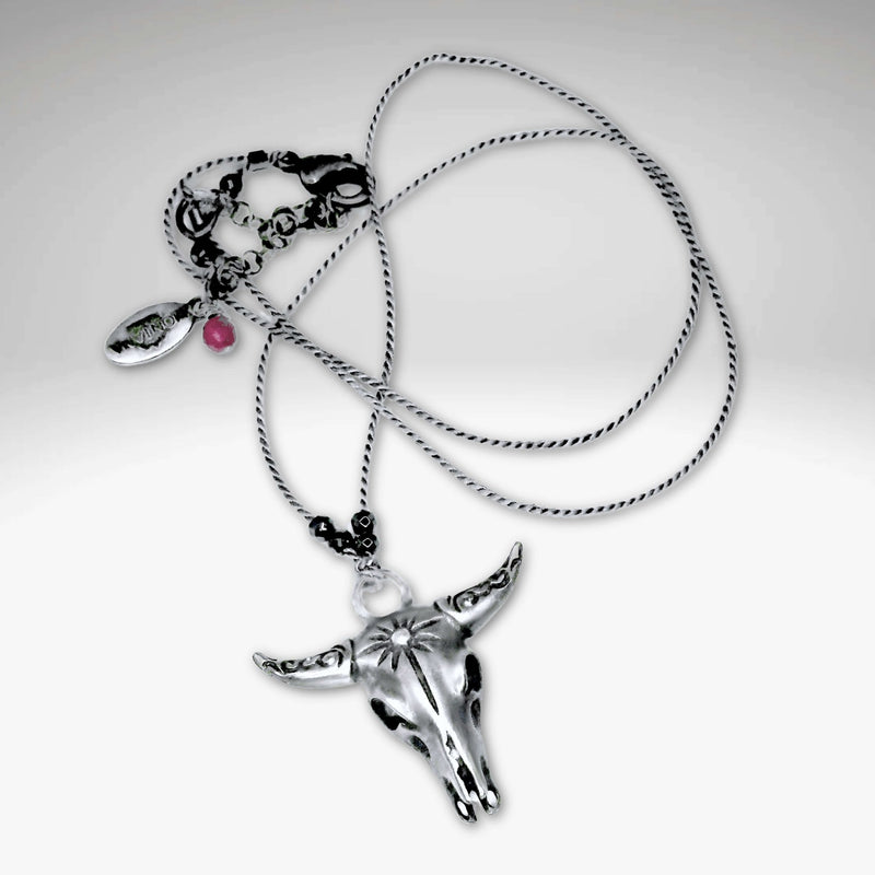 Bison Skull Necklace featuring a striking silver pendant on a delicate silk cord with hematite beads.