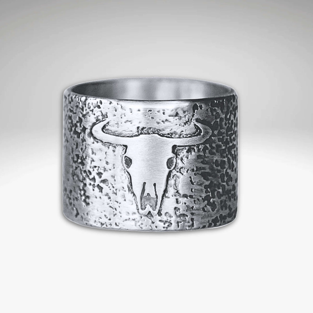 Bison Skull Ring featuring a unique bison skull design on a textured brass background.