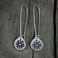 Bitterroot Drop Earrings in matte silver with kidney earwire on wooden background.