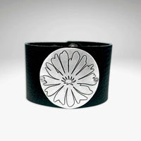 Bitterroot Leather Cuff featuring a matte silver flower design on a black leather band, adjustable and handmade in Montana.