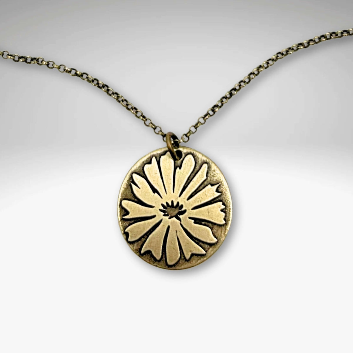 Bitterroot Necklace featuring a bold etching of the bitterroot flower on antique brass pendant.
