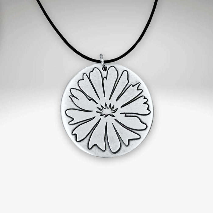 Bitterroot Necklace with fine line etching of a large bitterroot flower on a black cord.