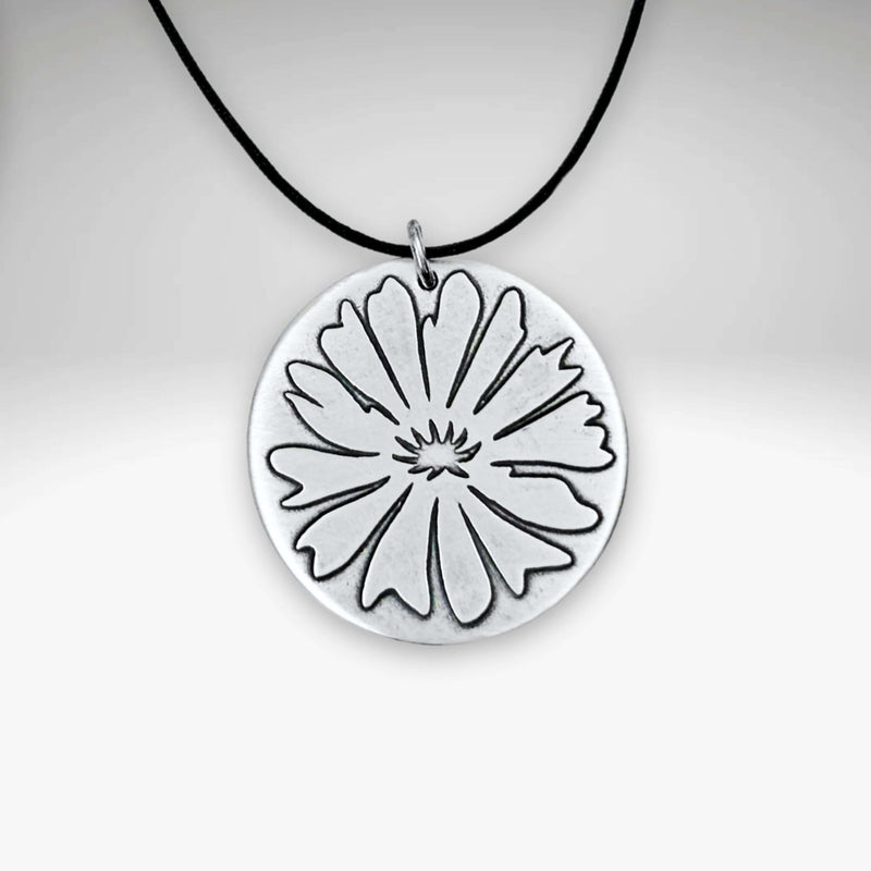 Bitterroot Necklace with fine line etching of a large bitterroot flower on a black cord.