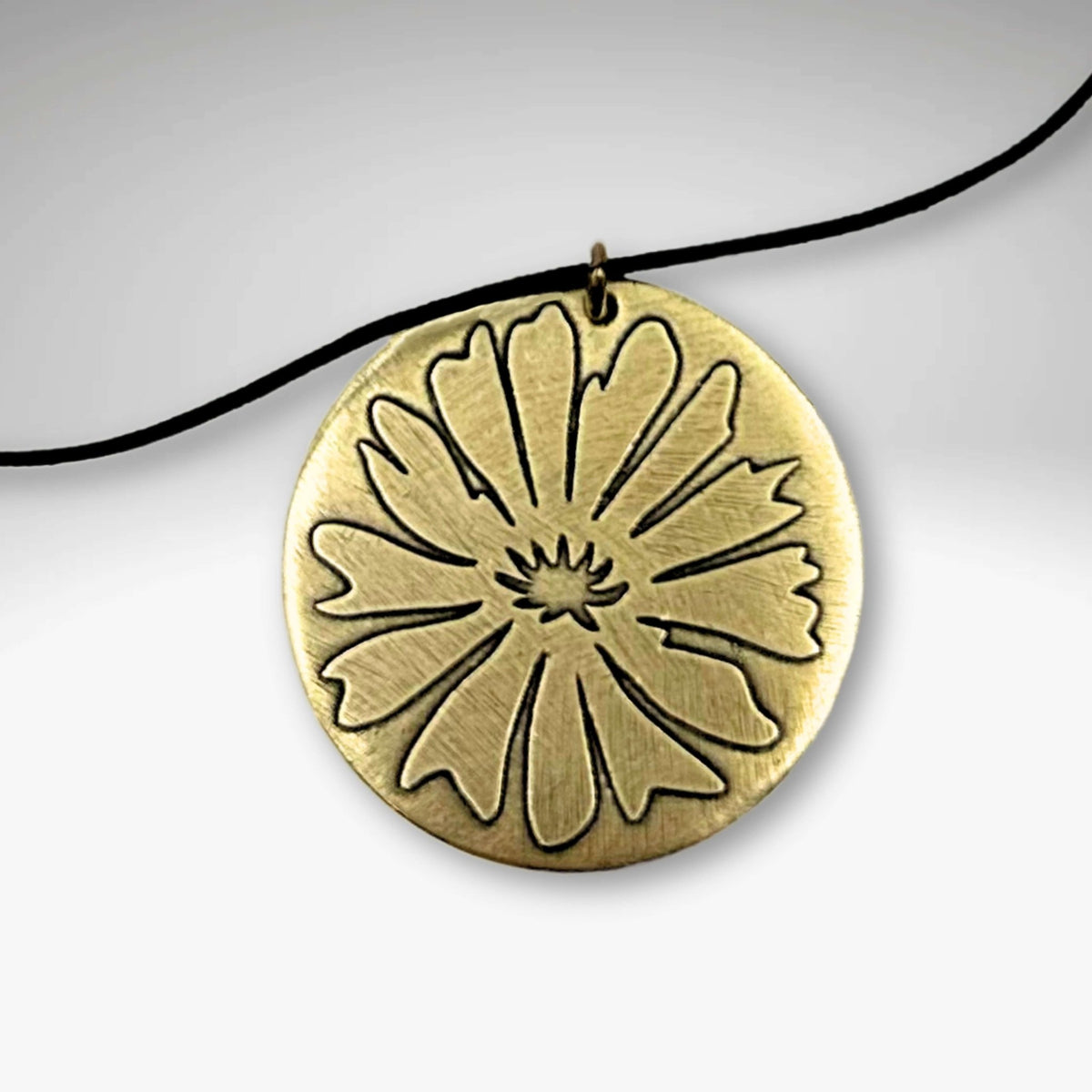 Bitterroot Necklace featuring a big etched flower pendant in Antique Brass, perfect for flower lovers.