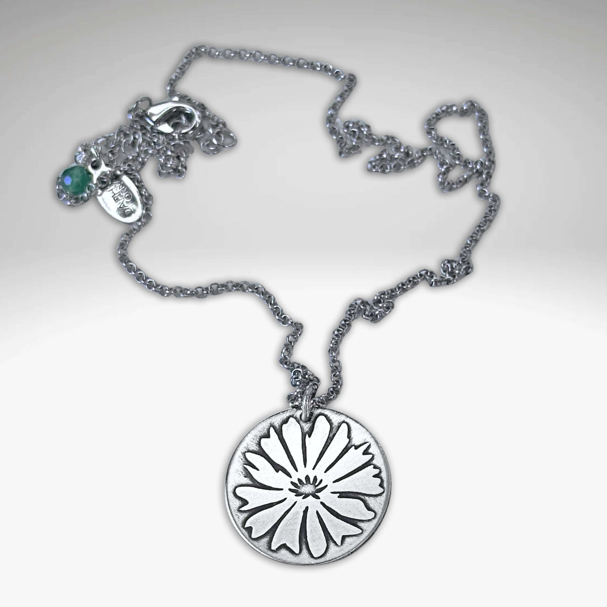 Bitterroot Necklace featuring fine line etching of a big bitterroot flower on a matte silver chain.