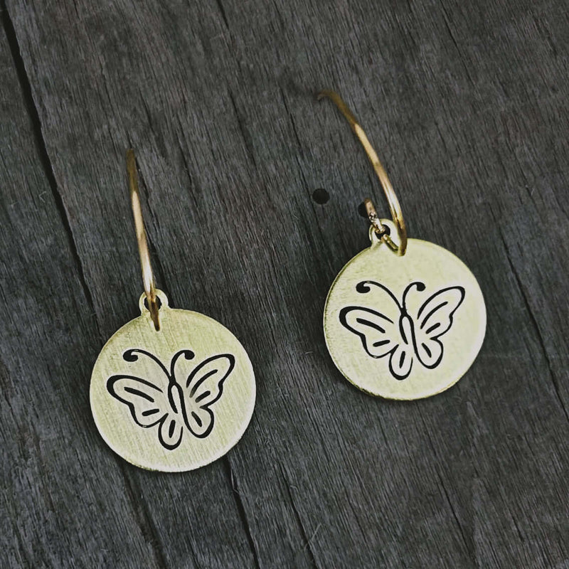Butterfly Earrings featuring intricately etched butterflies on round metal discs in antique brass finish.