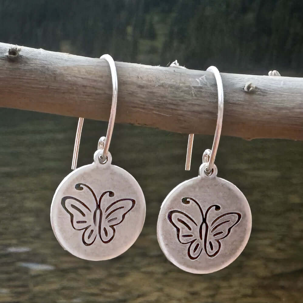 Butterfly Earrings with intricately etched butterflies in matte silver finish on a natural background.
