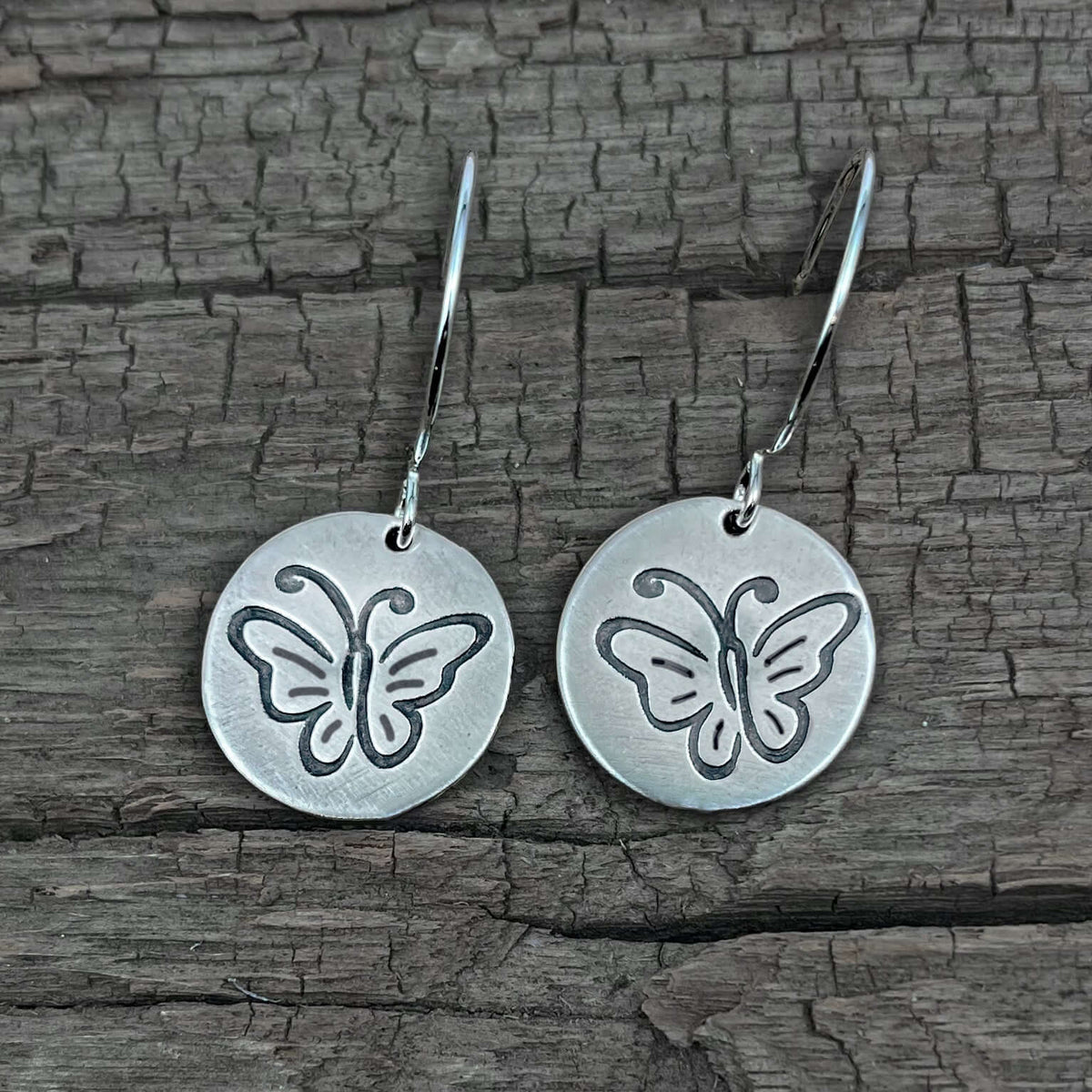 Butterfly Earrings in elegant dangle style with intricately etched butterflies on matte silver finish.