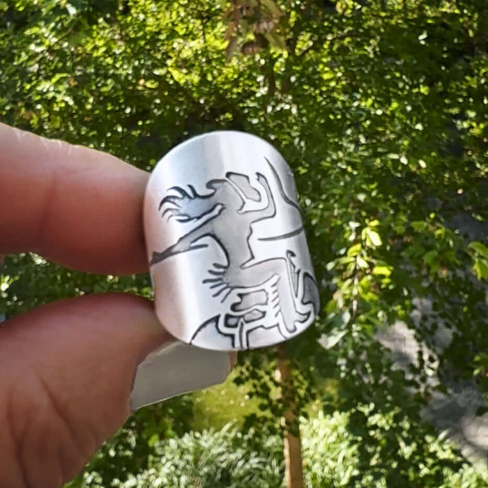 Cowgirl Adjustable Ring showcased against a green background, featuring a bold bucking bronco design.