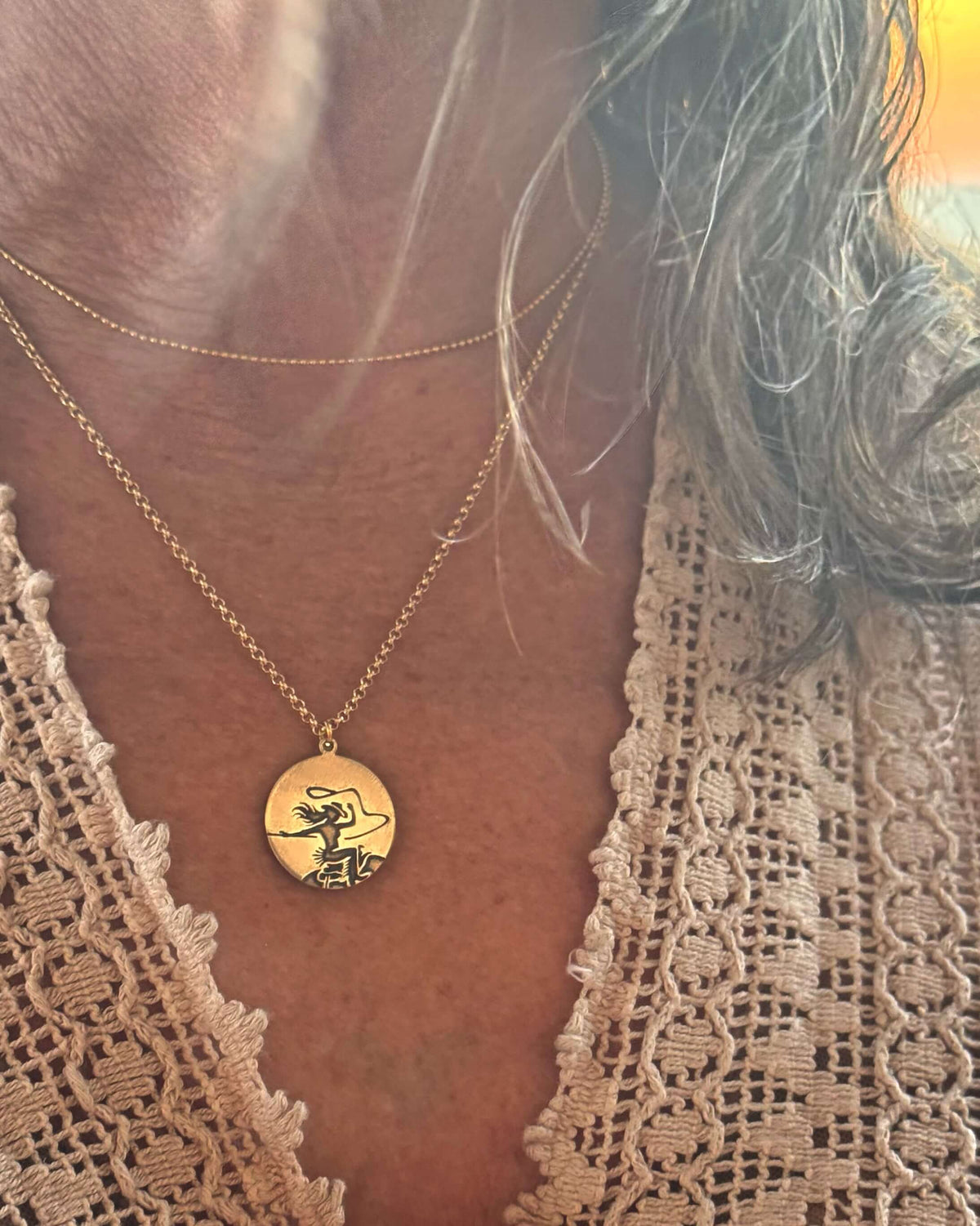 Close-up of a woman wearing a Cowgirl Necklace with a pendant depicting a cowgirl riding a horse.