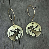 Creek Moose Earrings featuring intricate moose designs on circular pendants with hanging hooks