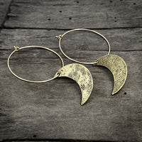 Crescent Moon Hoop Earrings on rustic wooden background, featuring hammered brass moons and gold-filled hoops.