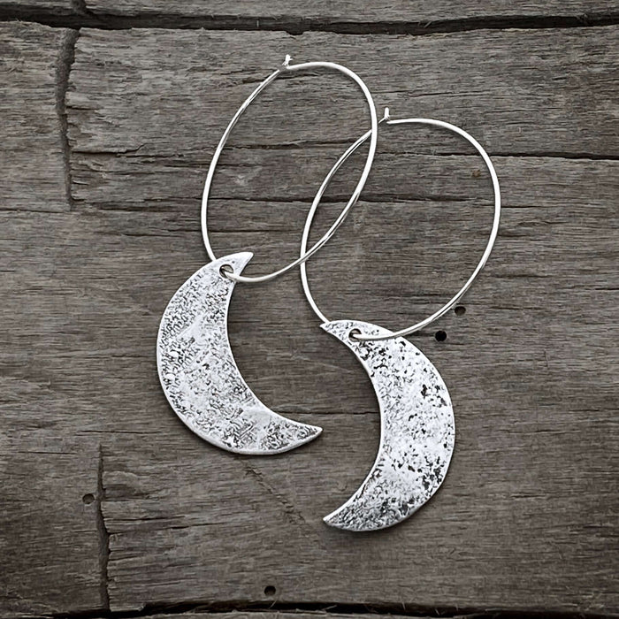Crescent Moon Hoop Earrings featuring hammered solid brass moons and sterling silver hoops, 1 inch diameter.