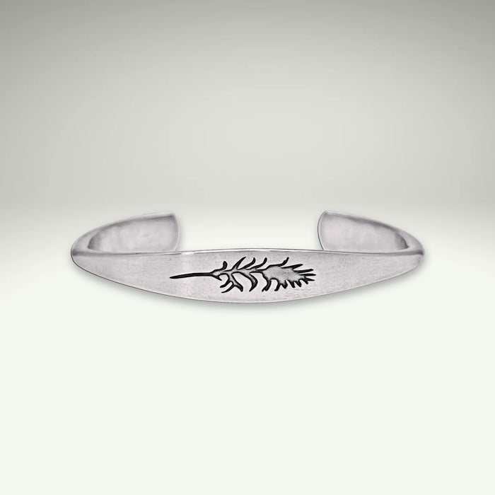 a silver bracelet with a leaf design on it