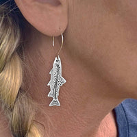Daphne Lorna Fishing Trout Earrings – Handmade Montana Wildlife Jewelry, Matte Silver or Antique Brass worn by a woman.