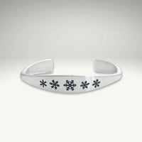 a silver bracelet with snowflakes on it