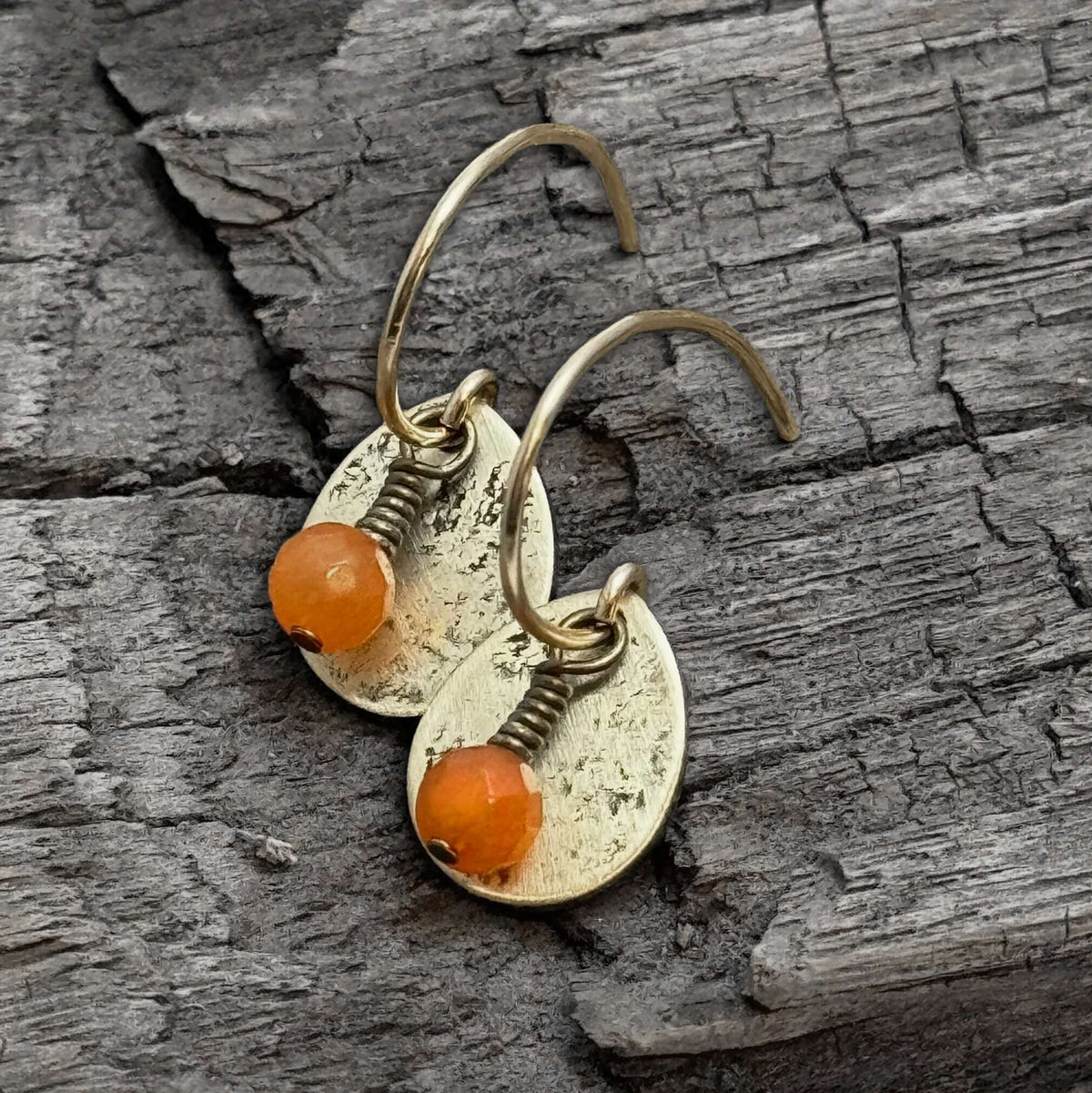 Drops Earrings featuring hand-textured brass teardrops with burnt orange jade beads for a stylish look.