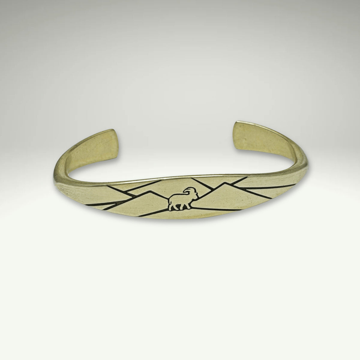 a gold bracelet with a bird on it