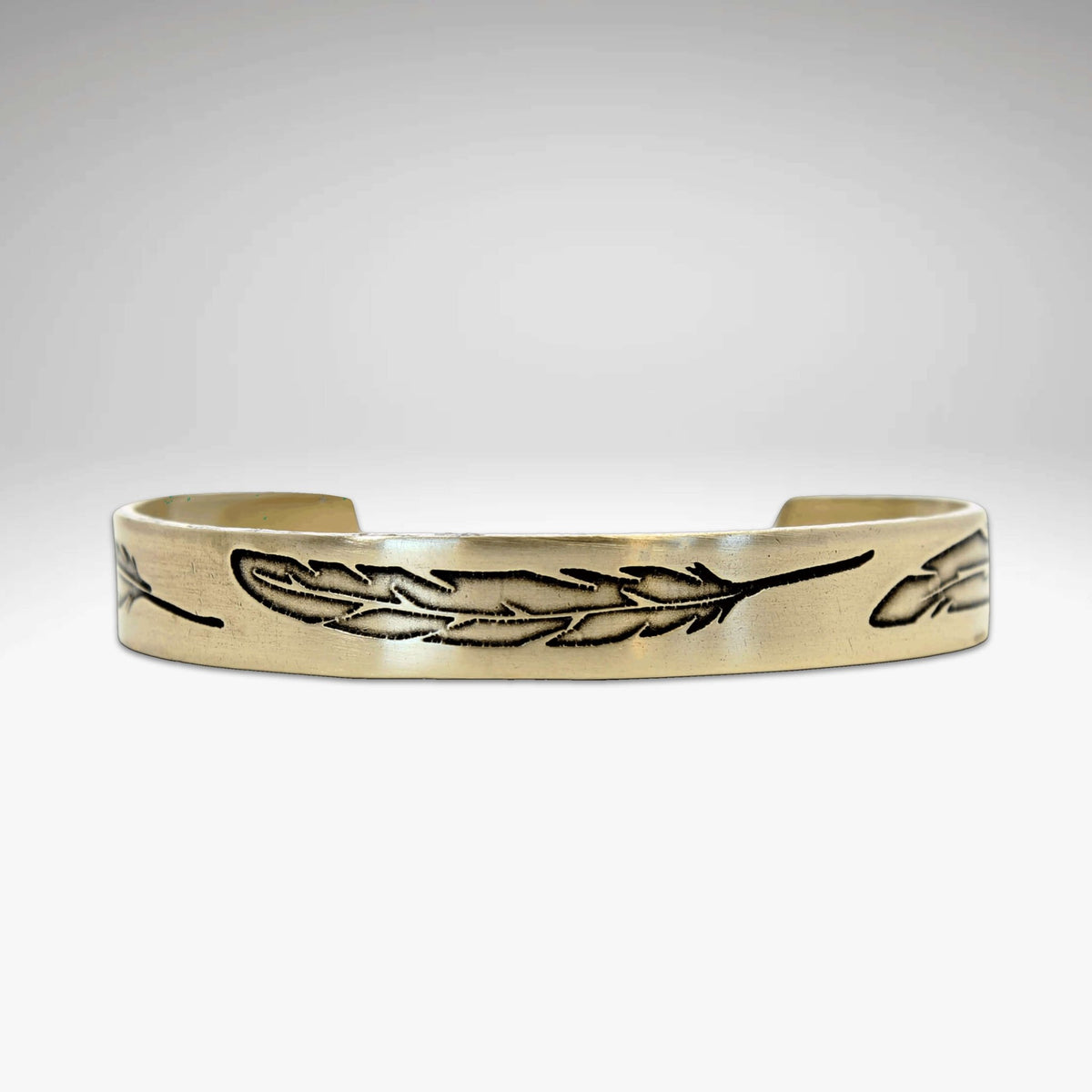 Feather Cuff Bracelet in antique brass finish featuring engraved feathers, adjustable design for a majestic look.