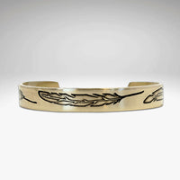 Feather Cuff Bracelet in antique brass finish featuring engraved feathers, adjustable design for a majestic look.