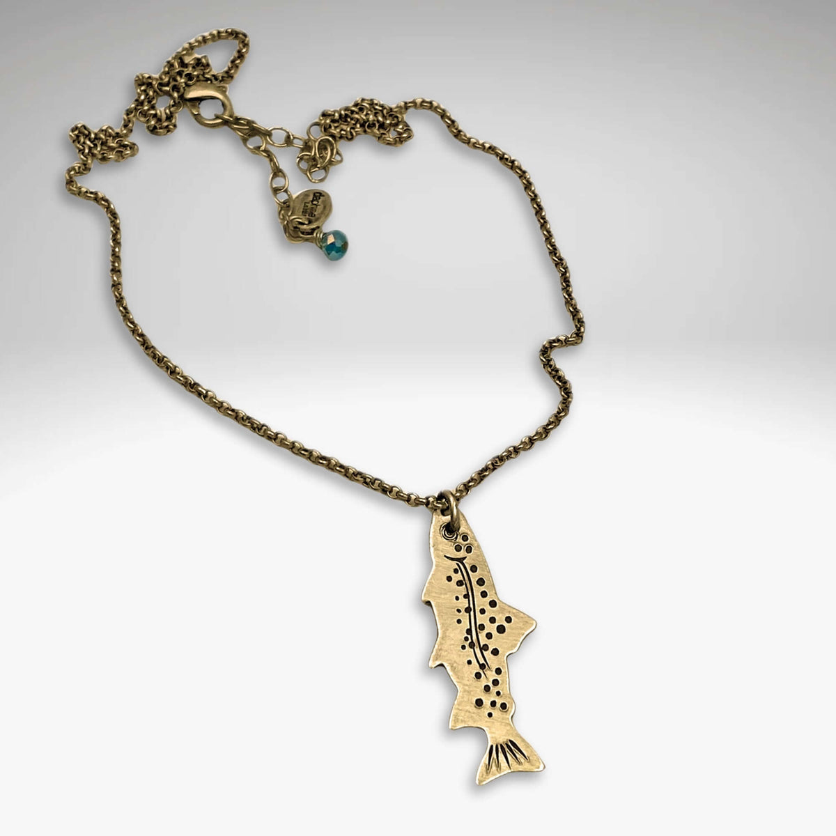 Fishin' Necklace featuring an antique brass fish pendant on a cable chain with a decorative clasp.