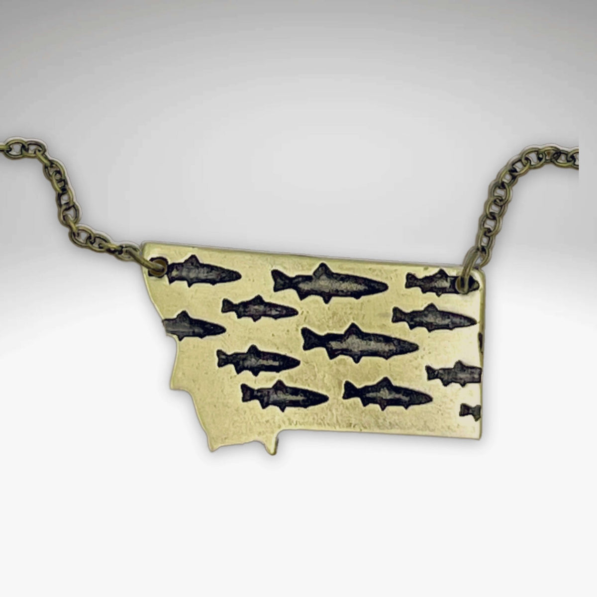 Fishing In Montana Necklace featuring etched trout design on Montana state outline.
