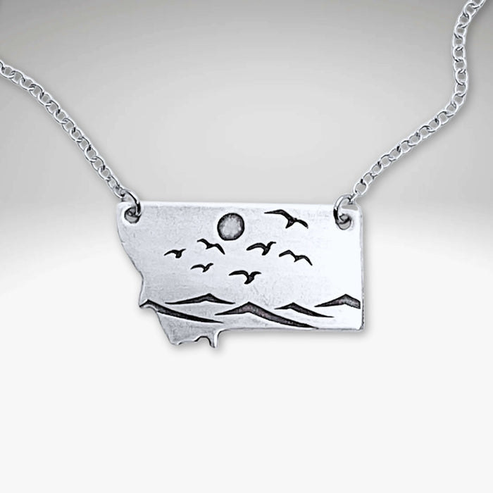 Flyover Montana - Necklace with Mountains birds and sun featuring a silver pendant showcasing nature.
