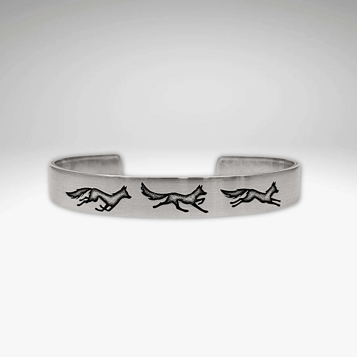 Fox Run Cuff Bracelet featuring playful foxes in a game of chase, available in matte silver finish.